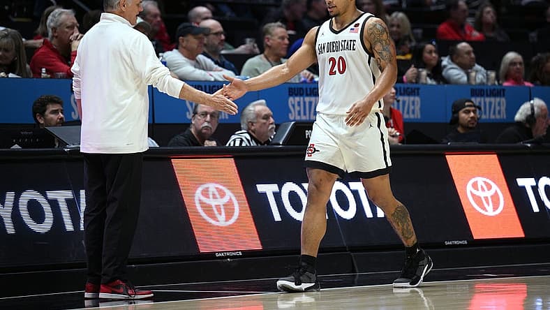 Dec 2, 2022; San Diego, California, USA; San Diego State Aztecs guard Matt Bradley (20) is greeted by head coach Brian Dutcher (left) during a substitution in the second half against the Occidental Tigers at Viejas Arena. Mandatory Credit: Orlando Ramirez-USA TODAY Sports