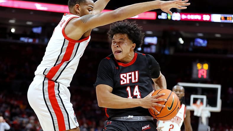 Dec 3, 2022; Columbus, Ohio, USA; St. Francis (Pa) Red Flash guard Landon Moore (14) is guarded closely by Ohio State Buckeyes guard Roddy Gayle Jr. (1) during the first half at Value City Arena. Mandatory Credit: Joseph Maiorana-USA TODAY Sports