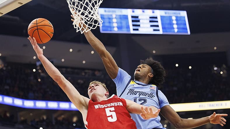 Dec 3, 2022; Milwaukee, Wisconsin, USA; Wisconsin Badgers forward Tyler Wahl (5) shoots against Marquette Golden Eagles forward Olivier-Maxence Prosper (12) during the first half at Fiserv Forum. Mandatory Credit: Jeff Hanisch-USA TODAY Sports