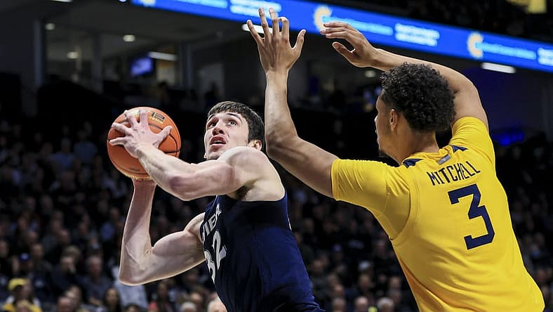 Dec 3, 2022; Cincinnati, Ohio, USA; Xavier Musketeers forward Zach Freemantle (32) drives to the basket against West Virginia Mountaineers forward Tre Mitchell (3) in the first half at Cintas Center. Mandatory Credit: Aaron Doster-USA TODAY Sports
