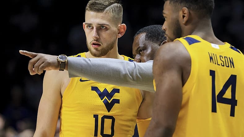 Dec 3, 2022; Cincinnati, Ohio, USA; West Virginia Mountaineers assistant coach Larry Harrison, middle, talks with guard Erik Stevenson (10) and guard Seth Wilson (14) during a stop in play against the Xavier Musketeers in the second half at Cintas Center. Mandatory Credit: Aaron Doster-USA TODAY Sports