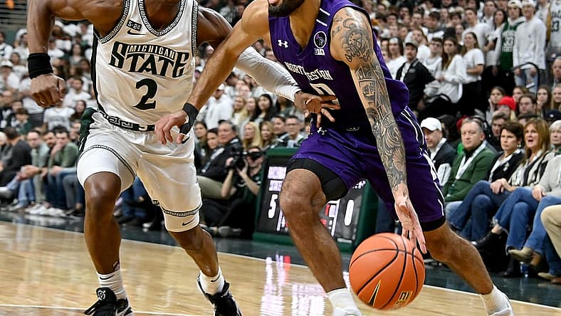 Dec 4, 2022; East Lansing, Michigan, USA; Northwestern Wildcats guard Boo Buie (0) drives the baseline against Michigan State Spartans guard Tyson Walker (2) at Jack Breslin Student Events Center. Mandatory Credit: Dale Young-USA TODAY Sports