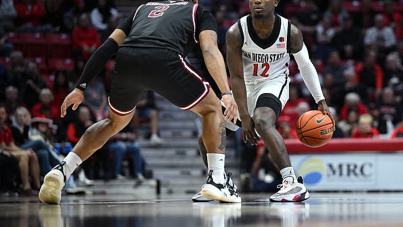Dec 5, 2022; San Diego, California, USA; San Diego State Aztecs guard Darrion Trammell (12) dribbles the ball while defended by Troy Trojans guard Aamer Muhammad (2) during the first half at Viejas Arena. Mandatory Credit: Orlando Ramirez-USA TODAY Sports
