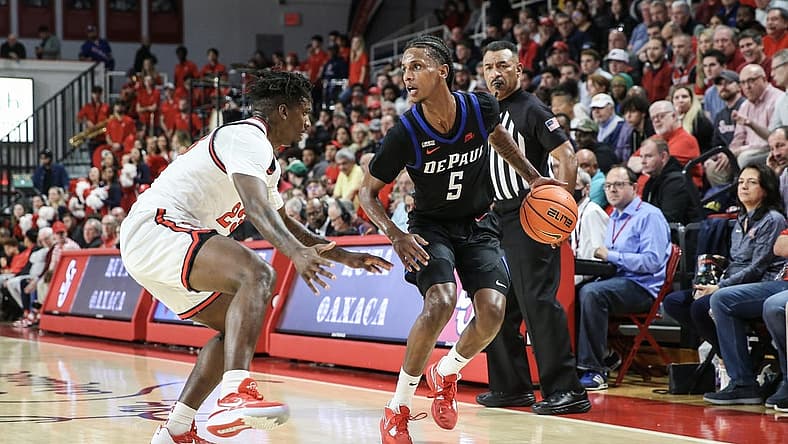 Dec 7, 2022; Queens, New York, USA; DePaul Blue Demons guard Philmon Gebrewhit (5) drives past St. John's Red Storm forward David Jones (23) in the first half at Carnesecca Arena. Mandatory Credit: Wendell Cruz-USA TODAY Sports