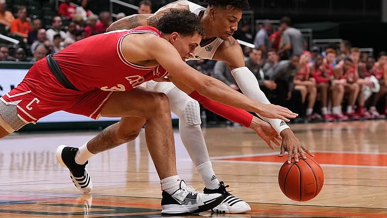 Dec 7, 2022; Coral Gables, Florida, USA; Miami Hurricanes guard Jordan Miller (11) and Cornell Big Red guard Chris Manon (30) battle for a loose ball during the first half at Watsco Center. Mandatory Credit: Jasen Vinlove-USA TODAY Sports