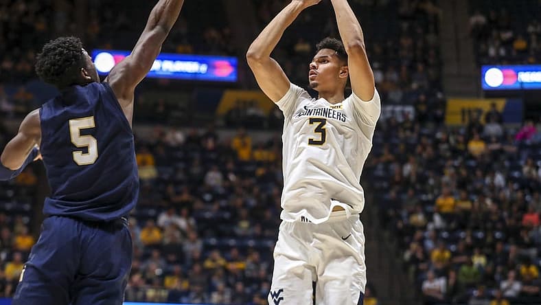 Dec 7, 2022; Morgantown, West Virginia, USA; West Virginia Mountaineers forward Tre Mitchell (3) shoots a three pointer over Navy Midshipmen forward Tyler Nelson (5) during the second half at WVU Coliseum. Mandatory Credit: Ben Queen-USA TODAY Sports