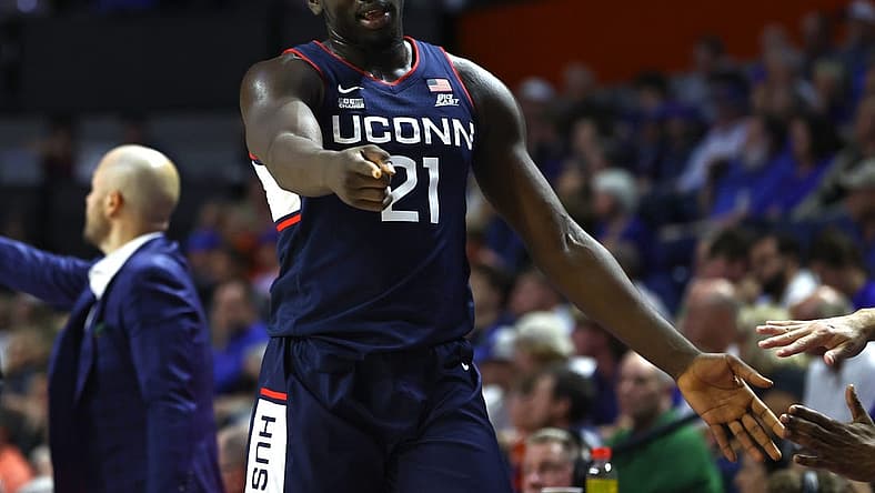 Dec 7, 2022; Gainesville, Florida, USA; Connecticut Huskies forward Adama Sanogo (21) points against the Florida Gators during the second half at Exactech Arena at the Stephen C. O'Connell Center. Mandatory Credit: Kim Klement-USA TODAY Sports