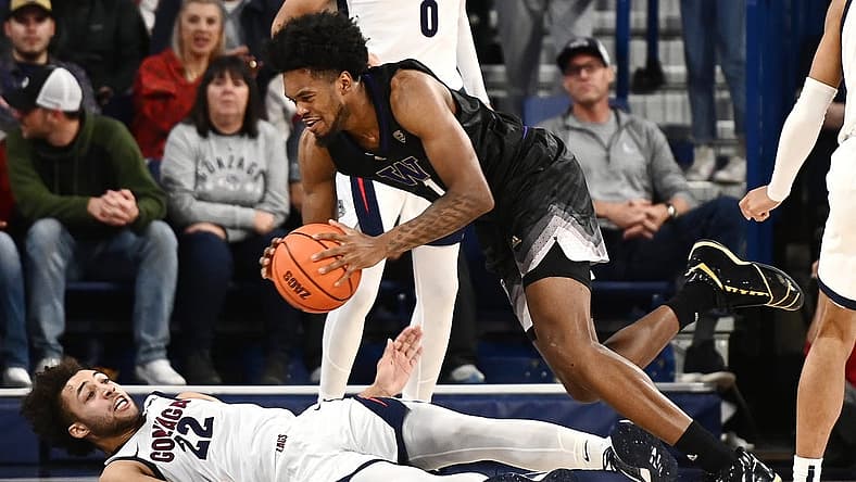 Dec 9, 2022; Spokane, Washington, USA; Gonzaga Bulldogs forward Anton Watson (22) takes the charge from Washington Huskies forward Keion Brooks (1) in the second half at McCarthey Athletic Center. Gonzaga won 77-60. Mandatory Credit: James Snook-USA TODAY Sports
