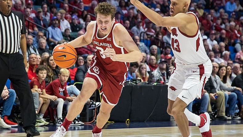 Dec 10, 2022; Tulsa, Oklahoma, USA; Oklahoma Sooners forward Jacob Groves (34) drives around Arkansas Razorbacks guard Jordan Walsh (13) during the first half at BOK Center. Mandatory Credit: Brett Rojo-USA TODAY Sports