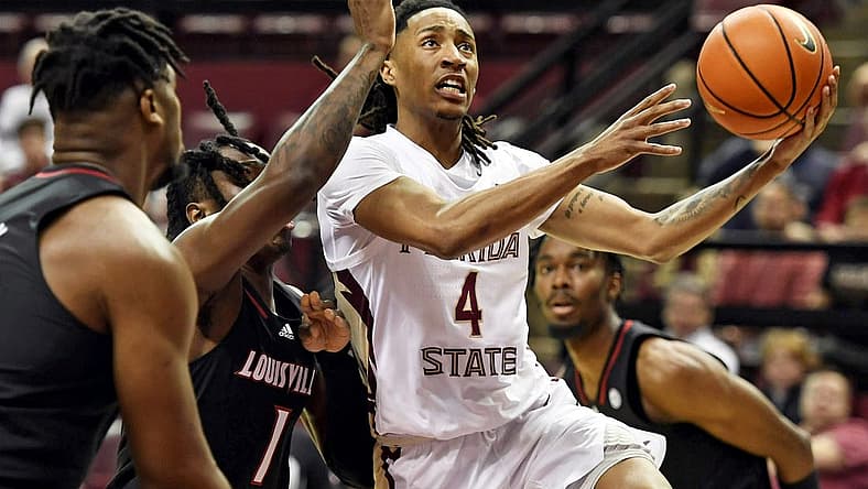 Dec 10, 2022; Tallahassee, Florida, USA; Florida State Seminoles guard Caleb Mills (4) shoots the ball past Louisville Cardinals guard Mike James (1) during the first half at Donald L. Tucker Center. Mandatory Credit: Melina Myers-USA TODAY Sports