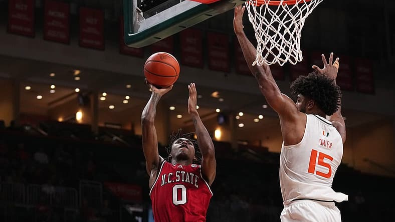 Dec 10, 2022; Coral Gables, Florida, USA; North Carolina State Wolfpack guard Terquavion Smith (0) shoots the ball in front of Miami Hurricanes forward Norchad Omier (15) during the first half at Watsco Center. Mandatory Credit: Jasen Vinlove-USA TODAY Sports