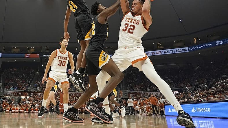 Dec 10, 2022; Austin, Texas, USA; Texas Longhorns forward Christian Bishop (32) drives to the basket against Arkansas Pine-Bluff Golden Lions forward Robert Lewis (22) and guard AC Curry (24) during the first half at Moody Center. Mandatory Credit: Scott Wachter-USA TODAY Sports