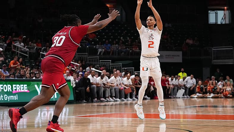 Dec 10, 2022; Coral Gables, Florida, USA; Miami Hurricanes guard Isaiah Wong (2) attempts a three point shot over North Carolina State Wolfpack forward D.J. Burns Jr. (30) during the second half at Watsco Center. Mandatory Credit: Jasen Vinlove-USA TODAY Sports