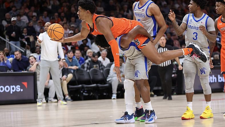 Dec 10, 2022; Atlanta, Georgia, USA; Auburn Tigers center Dylan Cardwell (44) lays on the back of Memphis Tigers guard Alex Lomax (2) in the first half at State Farm Arena. Mandatory Credit: Brett Davis-USA TODAY Sports