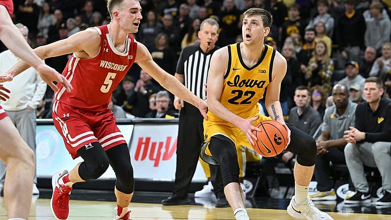 Dec 11, 2022; Iowa City, Iowa, USA; Iowa Hawkeyes forward Patrick McCaffery (22) is defended by Wisconsin Badgers forward Tyler Wahl (5) during overtime at Carver-Hawkeye Arena. Mandatory Credit: Jeffrey Becker-USA TODAY Sports