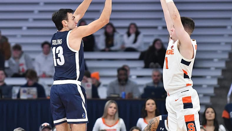 Dec 12, 2022; Syracuse, New York, USA; Monmouth Hawks guard Jack Collins (13) shoots from the corner as Syracuse Orange guard Joseph Girard III (11) defends in the first half at JMA Wireless Dome. Mandatory Credit: Mark Konezny-USA TODAY Sports