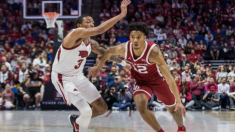 Dec 10, 2022; Tulsa, Oklahoma, USA;  Oklahoma Sooners guard Milos Uzan (12) drives around Arkansas Razorbacks guard Nick Smith Jr. (3) during the first half at BOK Center. Arkansas won 88-78. Mandatory Credit: Brett Rojo-USA TODAY Sports