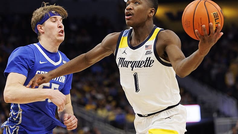 Dec 16, 2022; Milwaukee, Wisconsin, USA; Marquette Golden Eagles guard Kam Jones (1) drives for a shot around Creighton Bluejays guard Baylor Scheierman (55) during the second half at Fiserv Forum. Mandatory Credit: Jeff Hanisch-USA TODAY Sports