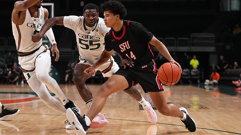 Dec 17, 2022; Coral Gables, Florida, USA; St. Francis Red Flash guard Landon Moore (14) drives the ball around Miami Hurricanes guard Wooga Poplar (55) and forward A.J. Casey (0) during the first half at Watsco Center. Mandatory Credit: Jasen Vinlove-USA TODAY Sports