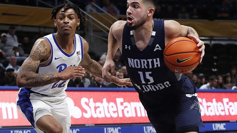 Dec 17, 2022; Pittsburgh, Pennsylvania, USA; North Florida Ospreys guard Jose Placer (15) dribbles the ball against Pittsburgh Panthers guard Nike Sibande (22) during the first half at the Petersen Events Center. Mandatory Credit: Charles LeClaire-USA TODAY Sports