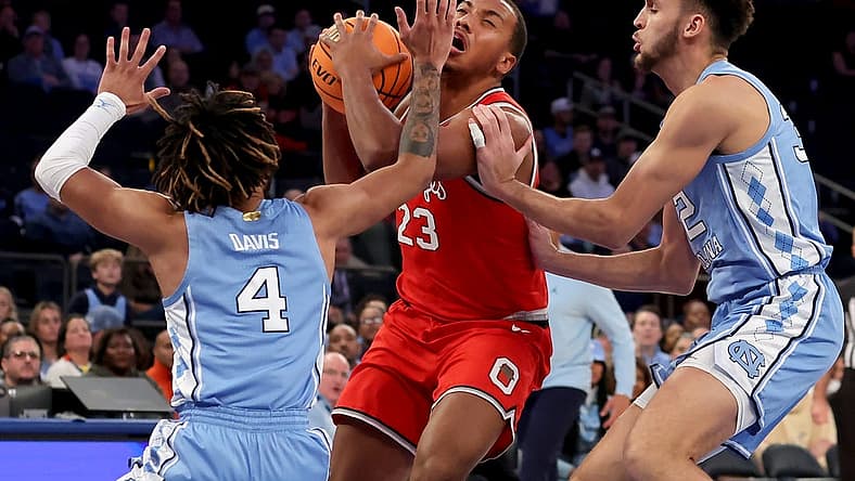Dec 17, 2022; New York, New York, USA; Ohio State Buckeyes forward Zed Key (23) is fouled by North Carolina Tar Heels forward Pete Nance (32) as he drives to the basket against Nance and Tar Heels guard R.J. Davis (4) during the first half at Madison Square Garden. Mandatory Credit: Brad Penner-USA TODAY Sports