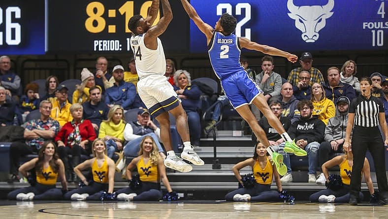 Dec 18, 2022; Morgantown, West Virginia, USA; West Virginia Mountaineers guard Seth Wilson (14) shoots over Buffalo Bulls guard Kidtrell Blocker (2) during the first half at WVU Coliseum. Mandatory Credit: Ben Queen-USA TODAY Sports