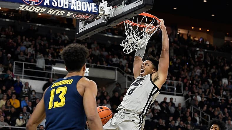 Dec 20, 2022; Providence, Rhode Island, USA; Providence Friars forward Ed Croswell (5) hangs from the basket after scoring against the Marquette Golden Eagles during the first half at Amica Mutual Pavilion. Mandatory Credit: Eric Canha-USA TODAY Sports