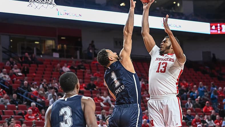 Dec 20, 2022; Lincoln, Nebraska, USA; Nebraska Cornhuskers forward Derrick Walker (13) scores over Queens Royals forward Mike Fowler (1) in the first half at Pinnacle Bank Arena. Mandatory Credit: Steven Branscombe-USA TODAY Sports