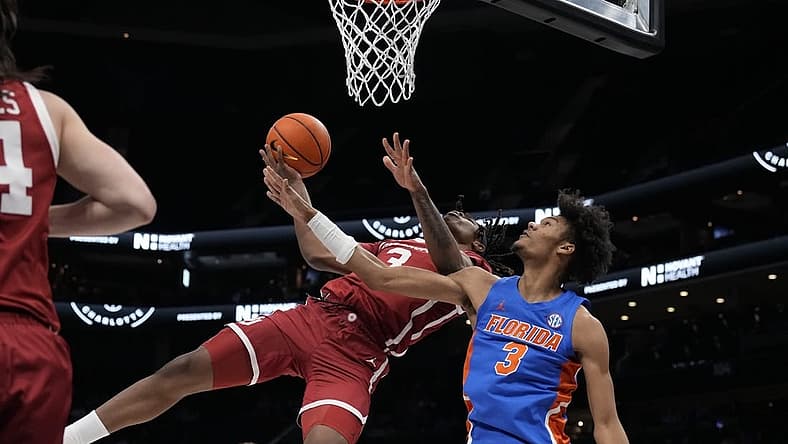 Dec 20, 2022; Charlotte, North Carolina, USA; Oklahoma Sooners guard Otega Oweh (3) gets fouled on his way to the basket by Florida Gators forward Alex Fudge (3) during the first half at the Jumpman Invitational at the Spectrum Center. Mandatory Credit: Jim Dedmon-USA TODAY Sports