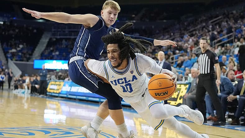 Dec 21, 2022; Los Angeles, California, USA; UCLA Bruins guard Tyger Campbell (right) dribbles the ball against UC Davis Aggies guard Leo DeBruhl in the second half at Pauley Pavilion presented by Wescom. UCLA defeated UC Davis 81-54. Mandatory Credit: Kirby Lee-USA TODAY Sports
