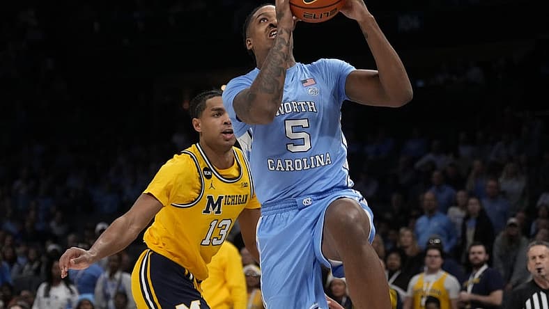 Dec 21, 2022; Charlotte, North Carolina, USA; North Carolina Tar Heels forward Armando Bacot (5) drives to the basket past Michigan Wolverines guard Jett Howard (13) during the first half at the Jumpman Classic at the Spectrum Center. Mandatory Credit: Jim Dedmon-USA TODAY Sports