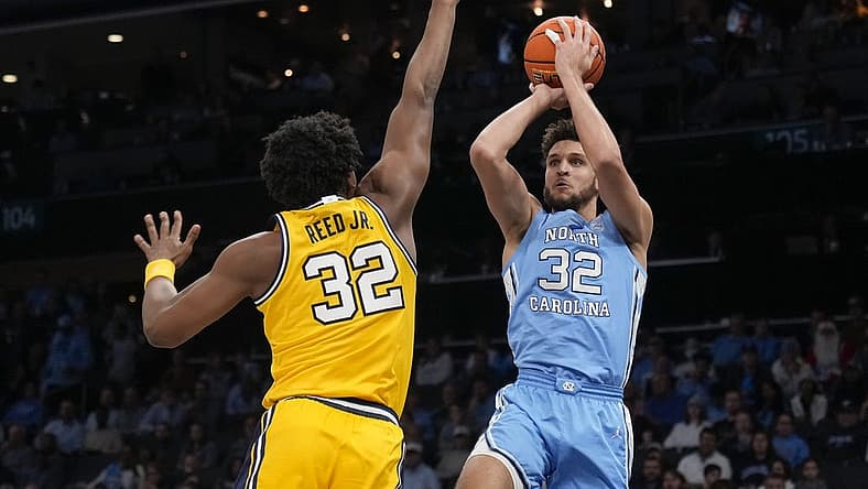 Dec 21, 2022; Charlotte, North Carolina, USA; North Carolina Tar Heels forward Pete Nance (32) shoots over Michigan Wolverines forward Tarris Reed Jr. (32) during the first half at the Jumpman Classic at the Spectrum Center. Mandatory Credit: Jim Dedmon-USA TODAY Sports