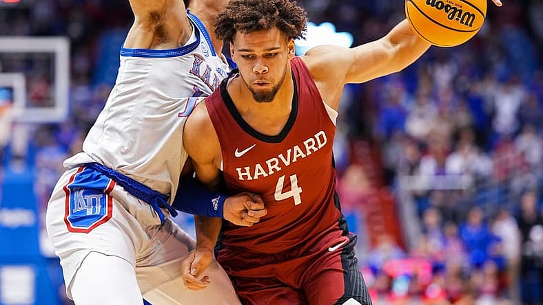 Dec 22, 2022; Lawrence, Kansas, USA; Harvard Crimson forward Chris Ledlum (4) drives against Kansas Jayhawks forward Jalen Wilson (10) during the first half at Allen Fieldhouse. Mandatory Credit: Jay Biggerstaff-USA TODAY Sports
