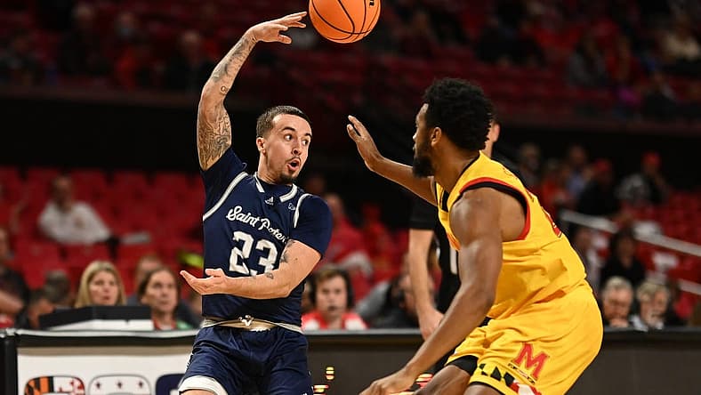 Dec 22, 2022; College Park, Maryland, USA; St. Peter's Peacocks guard Alex Rivera (23) passes over his head passMaryland Terrapins forward Donta Scott (24) during the first half at Xfinity Center. Mandatory Credit: Tommy Gilligan-USA TODAY Sports
