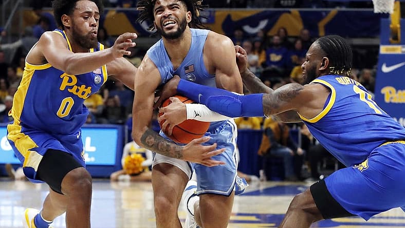 Dec 30, 2022; Pittsburgh, Pennsylvania, USA; North Carolina Tar Heels guard R.J. Davis (middle) drives to the basket between Pittsburgh Panthers guard Nelly Cummings (0) and guard Jamarius Burton (11) during the first half at Petersen Events Center. Mandatory Credit: Charles LeClaire-USA TODAY Sports