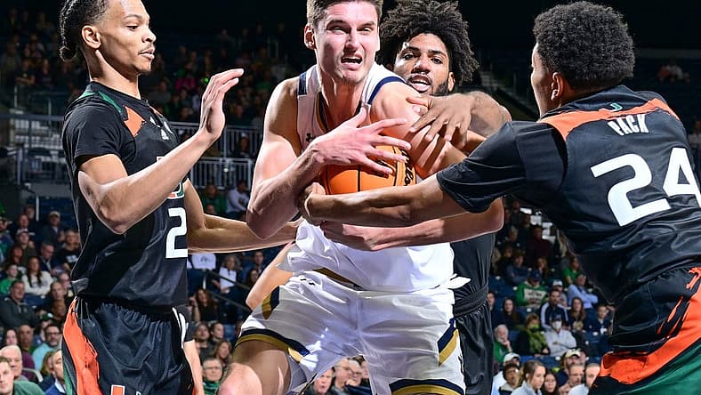 Dec 30, 2022; South Bend, Indiana, USA; Notre Dame Fighting Irish forward Nate Laszewski (14) grabs a rebound in front of Miami Hurricanes guard Isaiah Wong (2) guard Nijel Pack (24) and forward Norchad Omier (15) in the first half at the Purcell Pavilion. Mandatory Credit: Matt Cashore-USA TODAY Sports