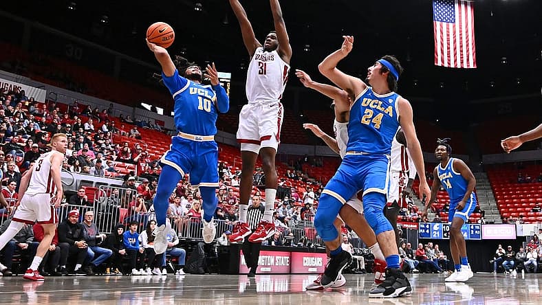 Dec 30, 2022; Pullman, Washington, USA; UCLA Bruins guard Tyger Campbell (10) shoots the ball against Washington State Cougars guard Kymany Houinsou (31) in the first half at Friel Court at Beasley Coliseum. Mandatory Credit: James Snook-USA TODAY Sports