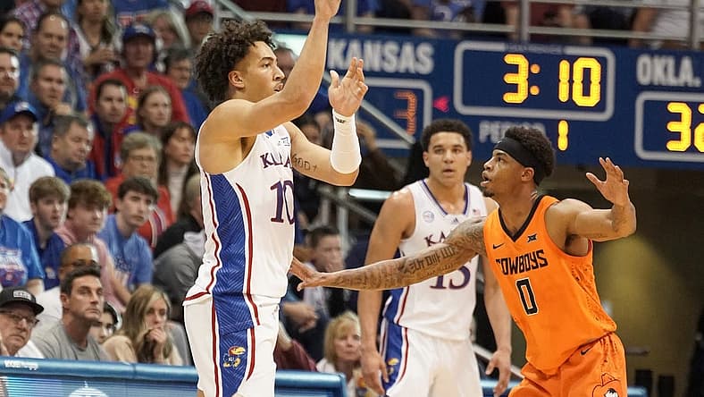 Dec 31, 2022; Lawrence, Kansas, USA; Kansas Jayhawks forward Jalen Wilson (10) passes as Oklahoma State Cowboys guard Avery Anderson III (0) defends during the first half at Allen Fieldhouse. Mandatory Credit: Denny Medley-USA TODAY Sports