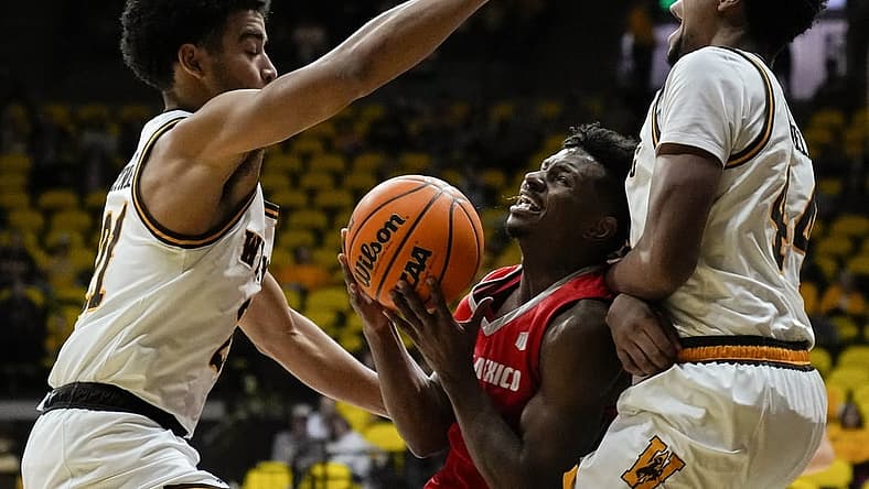 Dec 31, 2022; Laramie, Wyoming, USA; Wyoming Cowboys guard Noah Reynolds (21) and forward Caden Powell (44) trap New Mexico Lobos guard Jamal Mashburn Jr. (5) during the first half at Arena-Auditorium. Mandatory Credit: Troy Babbitt-USA TODAY Sports