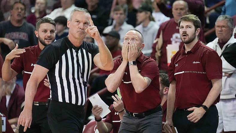 Nov 20, 2022; Charleston, South Carolina, USA; Official Ron Groover (stripes) points to a video board as Charleston Cougars head coach Pat Kelsey reacts in the back ground to a goaltending call in a game against the Virginia Tech Hokies at TD Arena. Mandatory Credit: David Yeazell-USA TODAY Sports