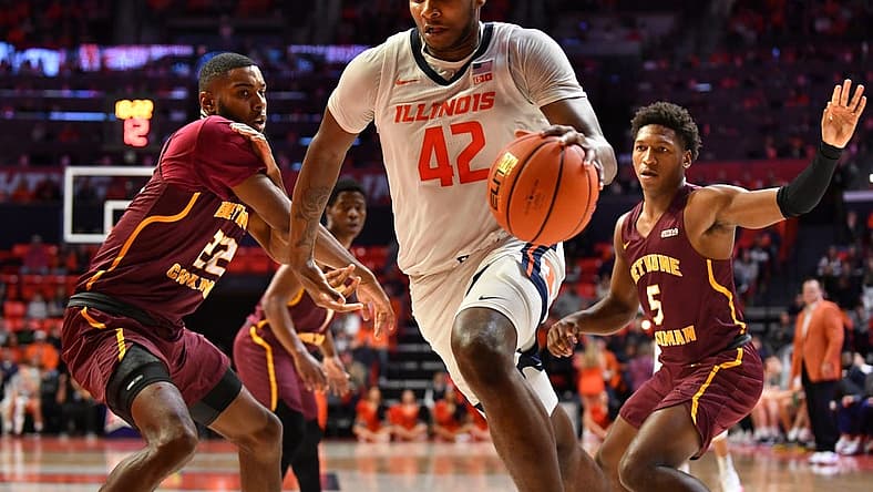Dec 29, 2022; Champaign, Illinois, USA; Illinois Fighting Illini forward Dain Dainja (42) drives ball past Bethune-Cookman Wildcats center Dylan Robertson (22) during the first half at State Farm Center. Mandatory Credit: Ron Johnson-USA TODAY Sports