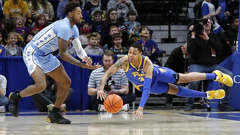 Dec 30, 2022; Pittsburgh, Pennsylvania, USA; North Carolina Tar Heels forward Leaky Black (left) and Pittsburgh Panthers guard Greg Elliott (3) reach for a loose ball during the first half at Petersen Events Center. Mandatory Credit: Charles LeClaire-USA TODAY Sports