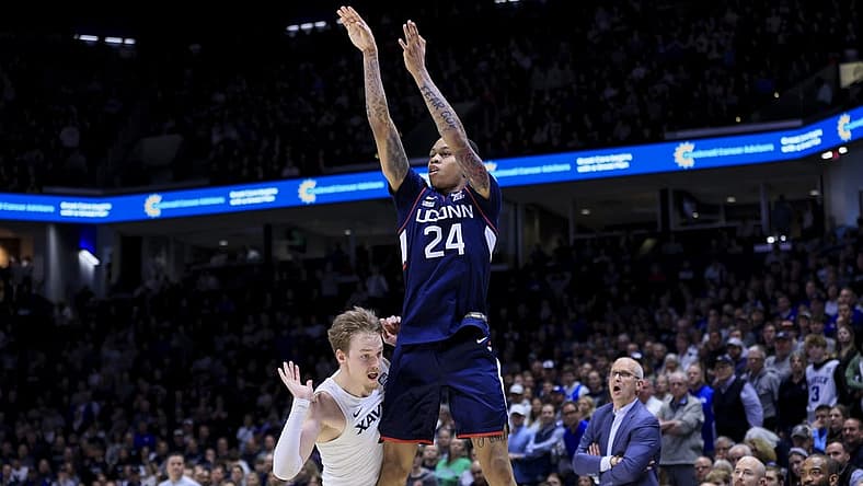 Dec 31, 2022; Cincinnati, Ohio, USA;  Xavier Musketeers guard Adam Kunkel (left) reacts as he fouls Connecticut Huskies guard Jordan Hawkins (24) while he attempts a three-point basket in the second half at the Cintas Center. Mandatory Credit: Aaron Doster-USA TODAY Sports