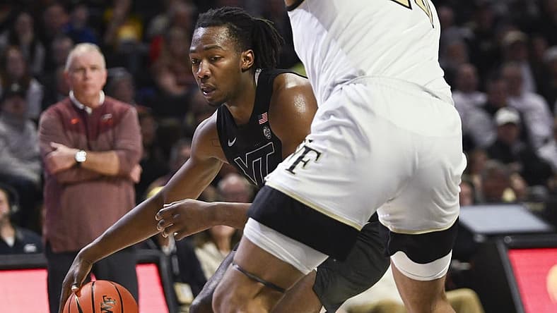 Dec 31, 2022; Winston-Salem, North Carolina, USA; Virginia Tech Hokies forward Justyn Mutts (25) dribbles around Wake Forest Demon Deacons forward Davion Bradford (20) during the second half at Lawrence Joel Veterans Memorial Coliseum. Mandatory Credit: William Howard-USA TODAY Sports