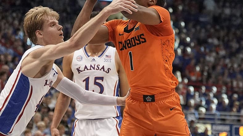 Dec 31, 2022; Lawrence, Kansas, USA; Oklahoma State Cowboys guard Bryce Thompson (1) shoots and is fouled by Kansas Jayhawks guard Gradey Dick (4) during the first half at Allen Fieldhouse. Mandatory Credit: Denny Medley-USA TODAY Sports