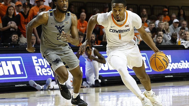 Jan 2, 2023; Stillwater, Oklahoma, USA; Oklahoma State Cowboys guard Bryce Thompson (1) drives to the basket ahead of West Virginia Mountaineers guard Kobe Johnson (2) during the first half at Gallagher-Iba Arena. Mandatory Credit: Alonzo Adams-USA TODAY Sports