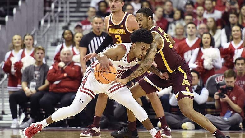 Jan 3, 2023; Madison, Wisconsin, USA; Wisconsin Badgers guard Chucky Hepburn (23) dribbles the ball under coverage by Minnesota Golden Gophers guard Ta'lon Cooper (55) during the first half at the Kohl Center. Mandatory Credit: Kayla Wolf-USA TODAY Sports