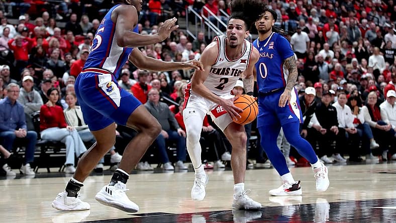 Jan 3, 2023; Lubbock, Texas, USA;  Texas Tech Red Raiders guard Pop Isaacs (2) drives to the lane against Kansas Jayhawks forward Zuby Ejiofor (35) in the first half at United Supermarkets Arena. Mandatory Credit: Michael C. Johnson-USA TODAY Sports