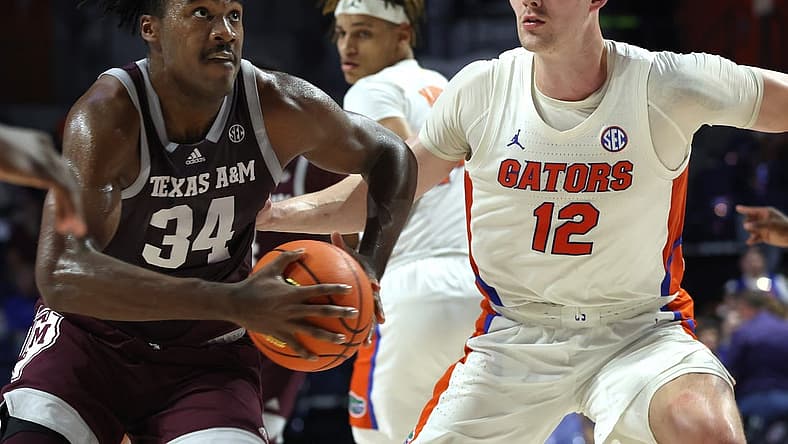 Jan 4, 2023; Gainesville, Florida, USA; Texas A&M Aggies forward Julius Marble (34) drives to the basket as Florida Gators forward Colin Castleton (12) defends during the first half at Exactech Arena at the Stephen C. O'Connell Center. Mandatory Credit: Kim Klement-USA TODAY Sports