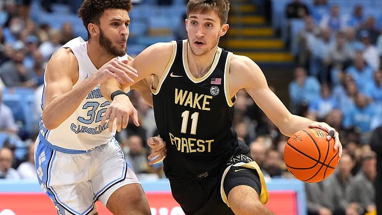 Jan 4, 2023; Chapel Hill, North Carolina, USA; Wake Forest Demon Deacons forward Andrew Carr (11) dribbles as North Carolina Tar Heels forward Pete Nance (32) defends in the first half at Dean E. Smith Center. Mandatory Credit: Bob Donnan-USA TODAY Sports